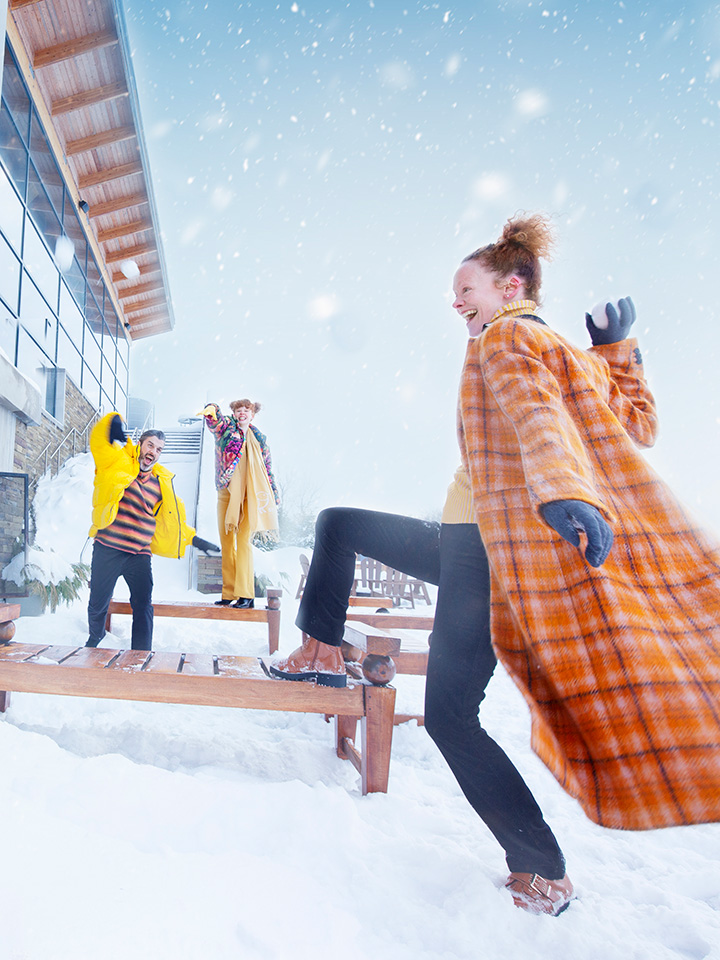 A family throwing snowballs at each other in the winter