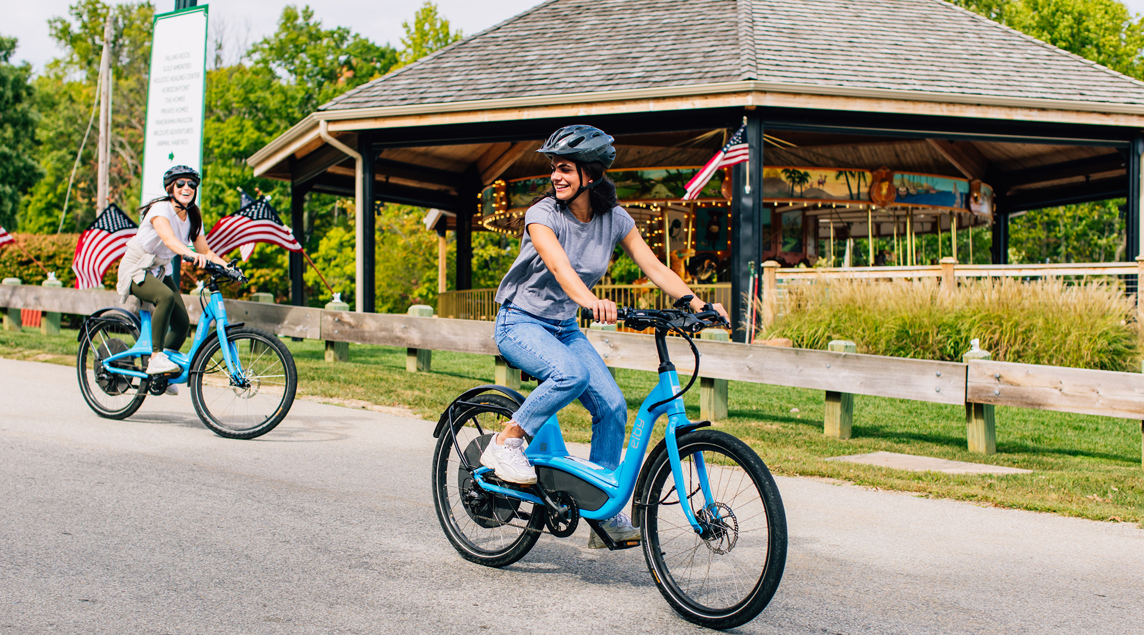 Woman riding blue electric E-bike on a paved road