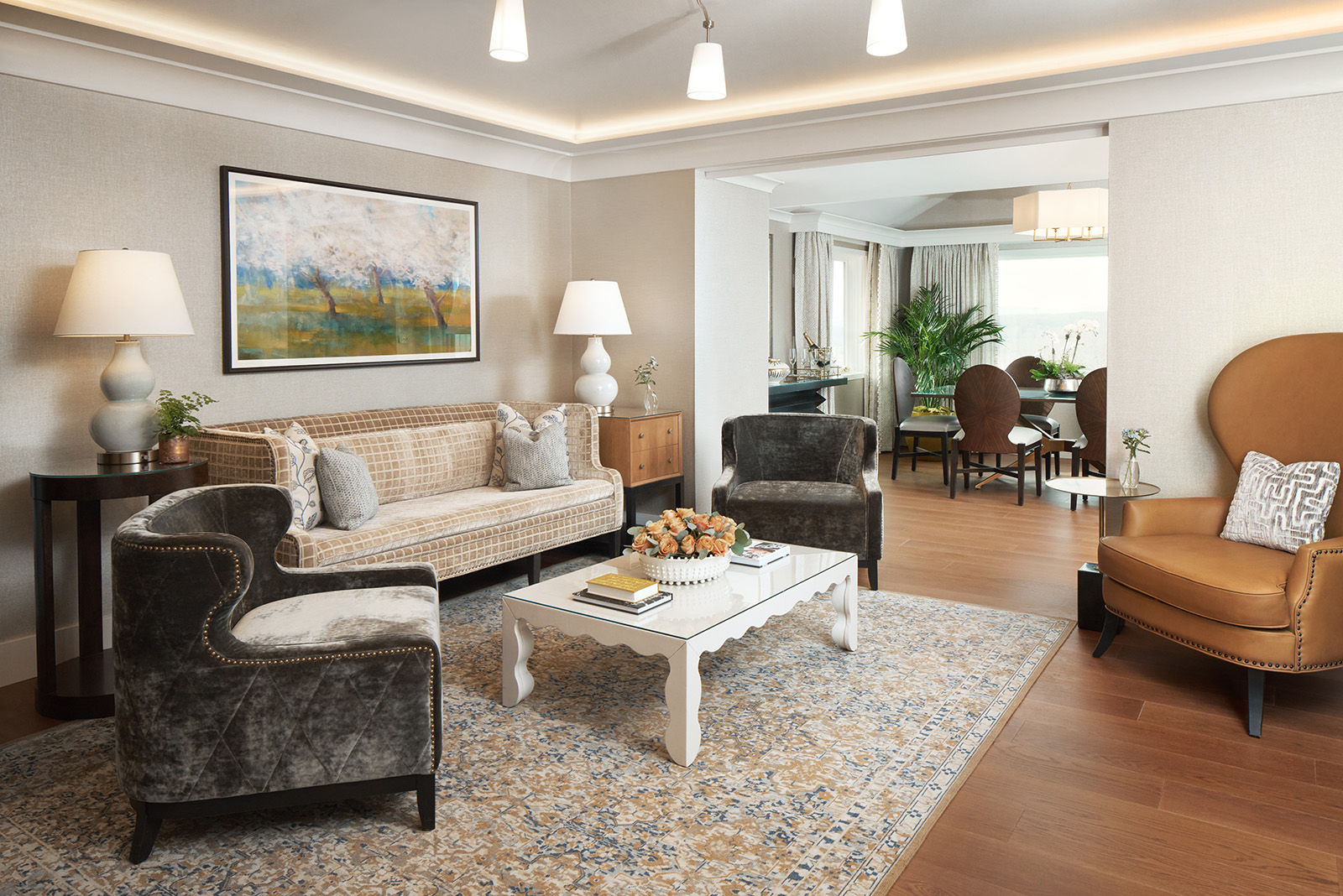 A serene view of one of The Grand Lodge's suites, showcasing a spacious bedroom with luxurious decor and warm tones.