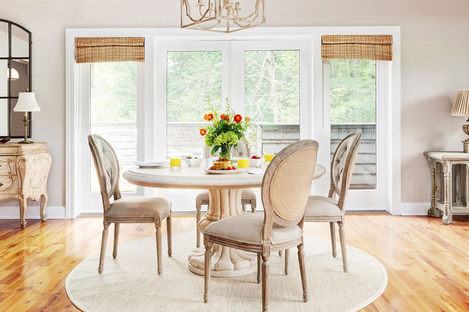 Dining room table with round table and four white chairs. Very clean and simple decor.