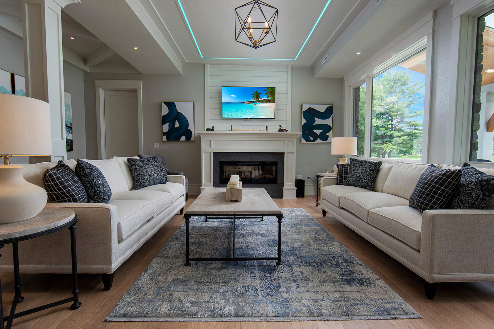 The view is inside the house in the living room, two couches with the tv on