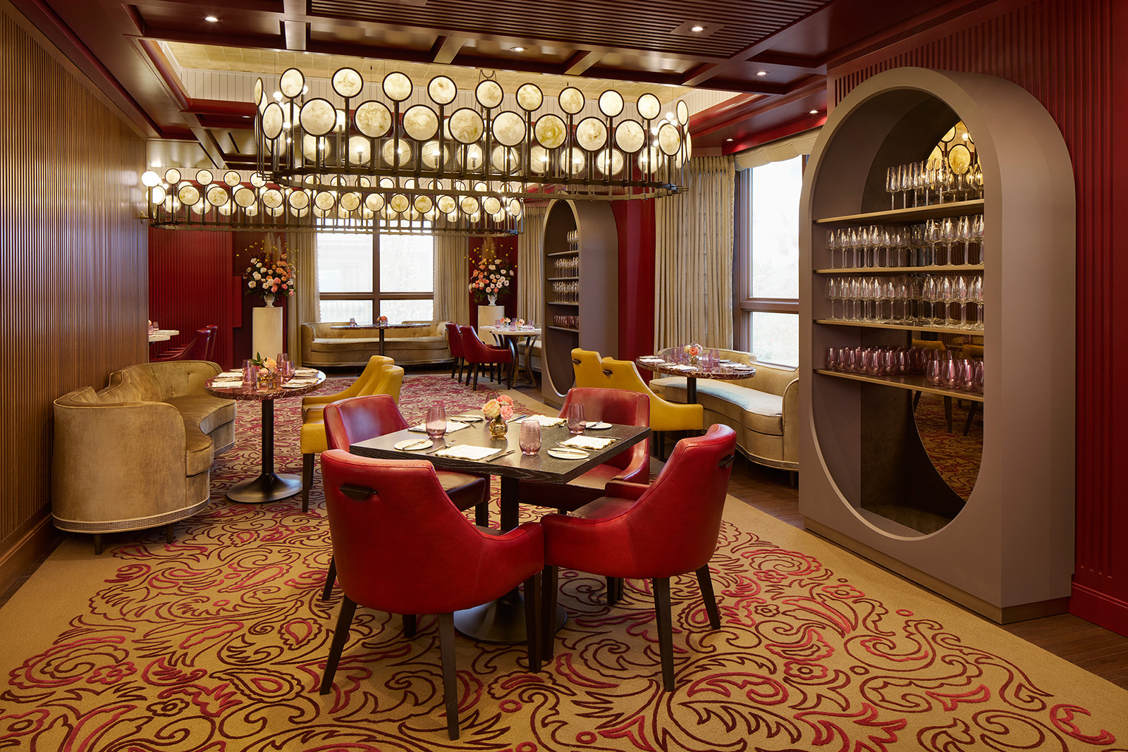 Indoor room with a square table, red chairs, large chandeliers