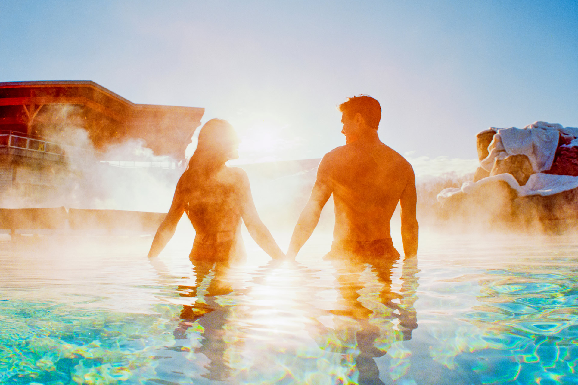 Open gallery overlay: a man and woman holding hands in a steaming pool